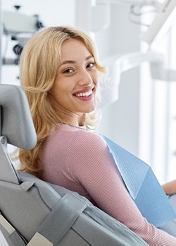 A relaxed and smiling young woman sitting in a dental chair