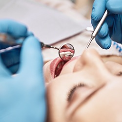 Smiling dentist talking to patient in exam room