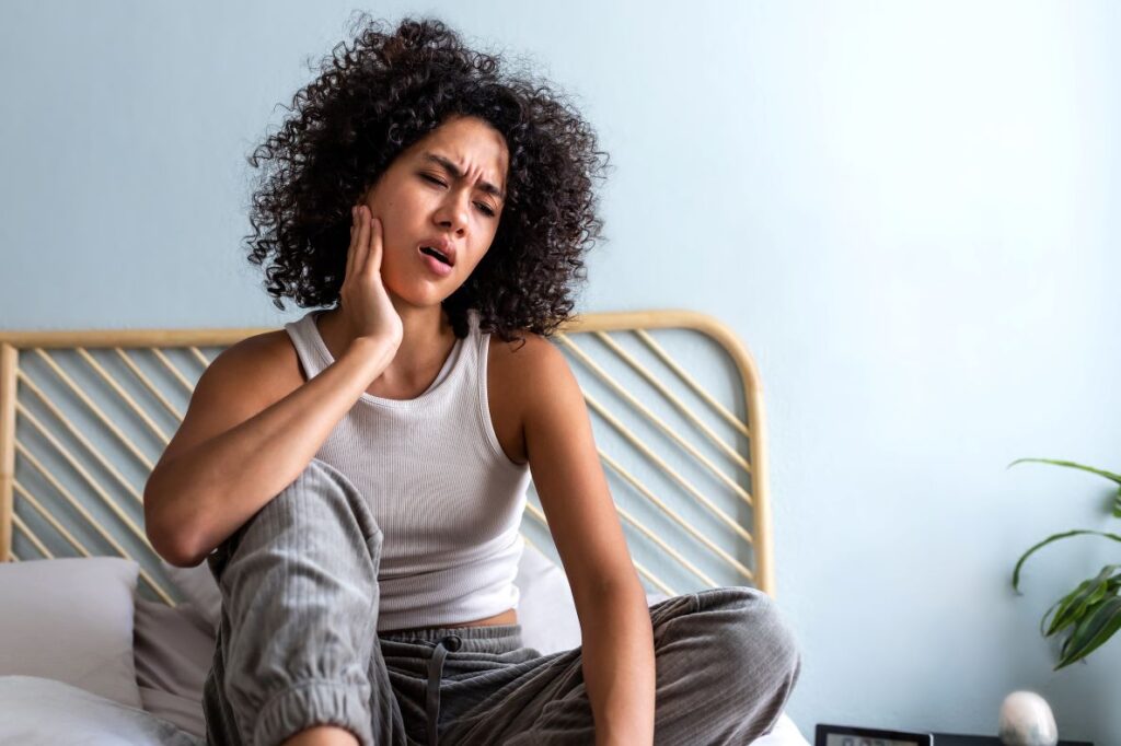 A woman with a toothache sitting in bed